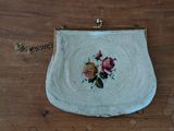 a white purse with flowers on it sitting on a table