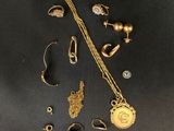 some of the gold jewelry is laid out on a black surface