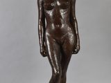 a bronze statue of a woman standing on top of a wooden base
