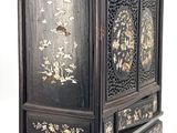 an image of a black wooden cabinet with flowers and birds painted on it
