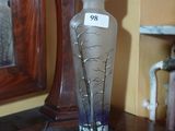 a glass vase sitting on top of a table next to a mirror