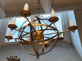 a chandelier and mirror in a room with a skylight above it