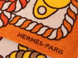 serviette orange et blanche sur laquelle est représenté un bateau et une corde