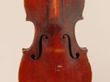 un vieux violon posé sur une surface blanche