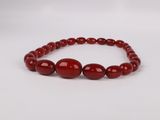 a red beaded bracelet with red glass beads on a white background