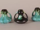 three black and blue vases sitting next to each other on a table