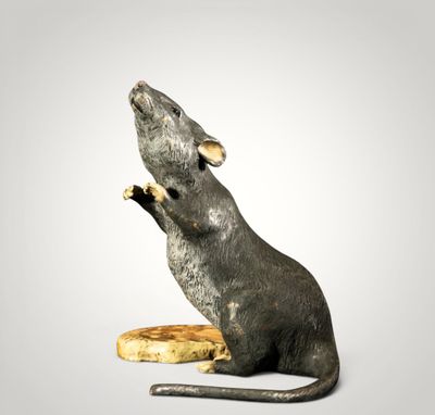 une statue représentant un rat assis sur une banane