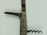 a knife that is laying on top of a corkscrew