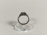 an image of a ring on a clear stand on a white surface