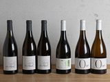 six bottles of wine are lined up in a row on a table