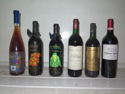 Des bouteilles de vin sont alignées sur une étagère dans une cuisine.