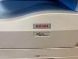 a close up of a rico printer with a blue background