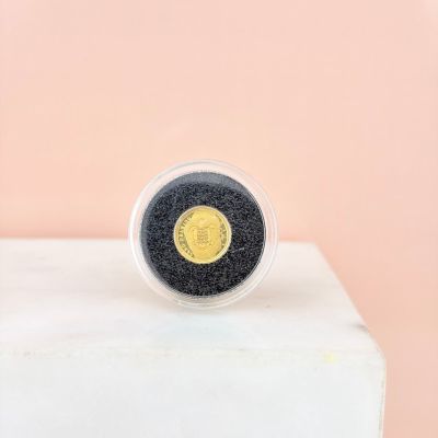 a gold and black coin ring sitting on top of a white block