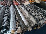 many rolls of fabric on a table in a room