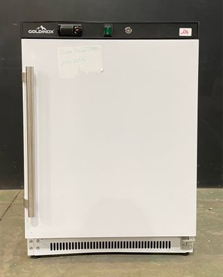 an image of a small white refrigerator on a concrete floor