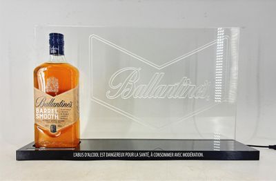 the bottle of ballant ' s bourbon sits next to a glass plaque