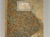 an old book with a blue and brown cover sitting on a table