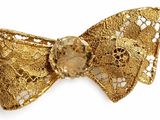 gold bow tie with a large crystal center on a white background