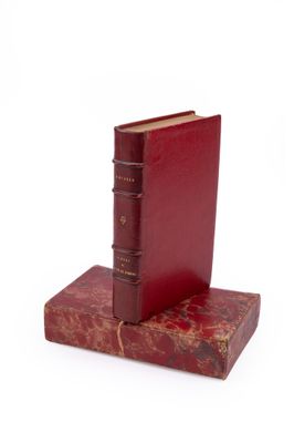 deux livres rouges posés l'un sur l'autre sur une surface blanche