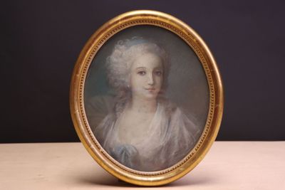 une vieille photo d'une femme en robe blanche dans un cadre doré
