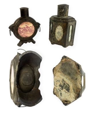Quatre types différents de lampes à huile anciennes sont exposés sur un support blanc