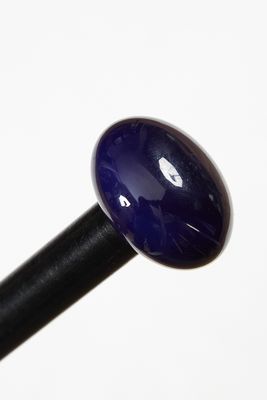 un gros plan d'une boule de verre bleue fixée à un bâton noir