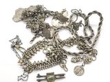 un tas de bijoux en argent posés sur une surface blanche