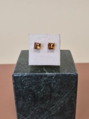 un gros plan sur une paire de boucles d'oreilles posées sur un bloc de marbre