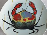a plate with a crab painted on it on a table