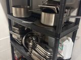 a black shelf with pots and pans on top of it
