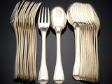 a lot of forks and spoons sitting on a table