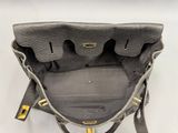 the back view of a black purse with a gold handle