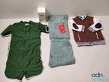 three baby clothes that are on a table next to a box