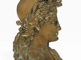 un buste antique en bronze représentant une femme coiffée d'un chapeau