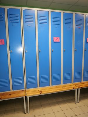 a row of blue lockers in a room with a bench