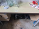 a wooden desk with a glass vase on it