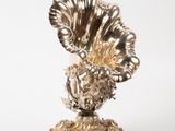 a silver vase with a large flower on top of it