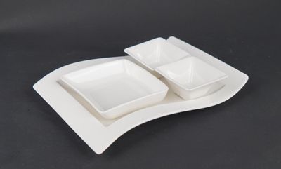 a white plate with two bowls on it on a black table
