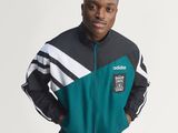 the young man is posing for a picture in a green and black jacket