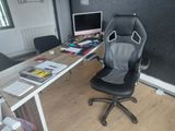 a desk with a chair and a computer on it