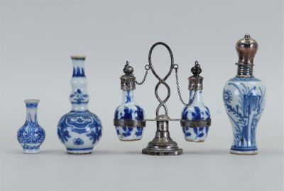 Plusieurs vases bleus et blancs sont alignés sur une surface blanche