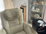 a reclining chair in a living room with a glass case