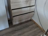 une lampe posée sur un pied à côté d'une commode