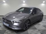 the mercedes cla is parked on a checkered floor in a garage