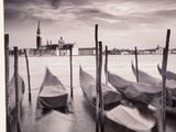 many boats that are tied to poles in the water