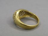 a close up of a gold ring with diamonds on a gray surface