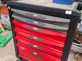 une armoire à outils rouge et noire avec des tiroirs, dans un garage