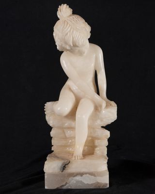 l'image d'une statue de femme assise au sommet d'un rocher