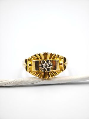 un gros plan d'une bague ornée d'une plume sur un fond blanc