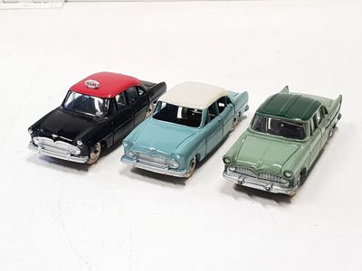 four toy cars are lined up in a row on a white surface